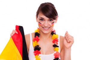 Junge Frau mit einer Deutschlandfahne in der Hand und Halskette in den Farben der Deutschlandfahne