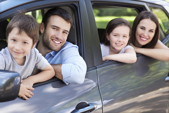 Eine Familie im Mietwagen unterwegs in den Urlaub